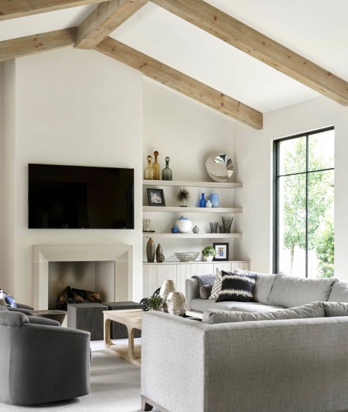 Simple room but powerful with the substantial beams and black windows and decorative elements on the shelves