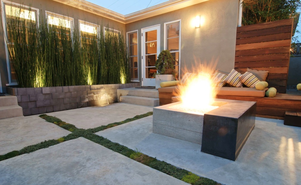 Concrete patio with soft joing.  architectural planting in front of windows.  firepit